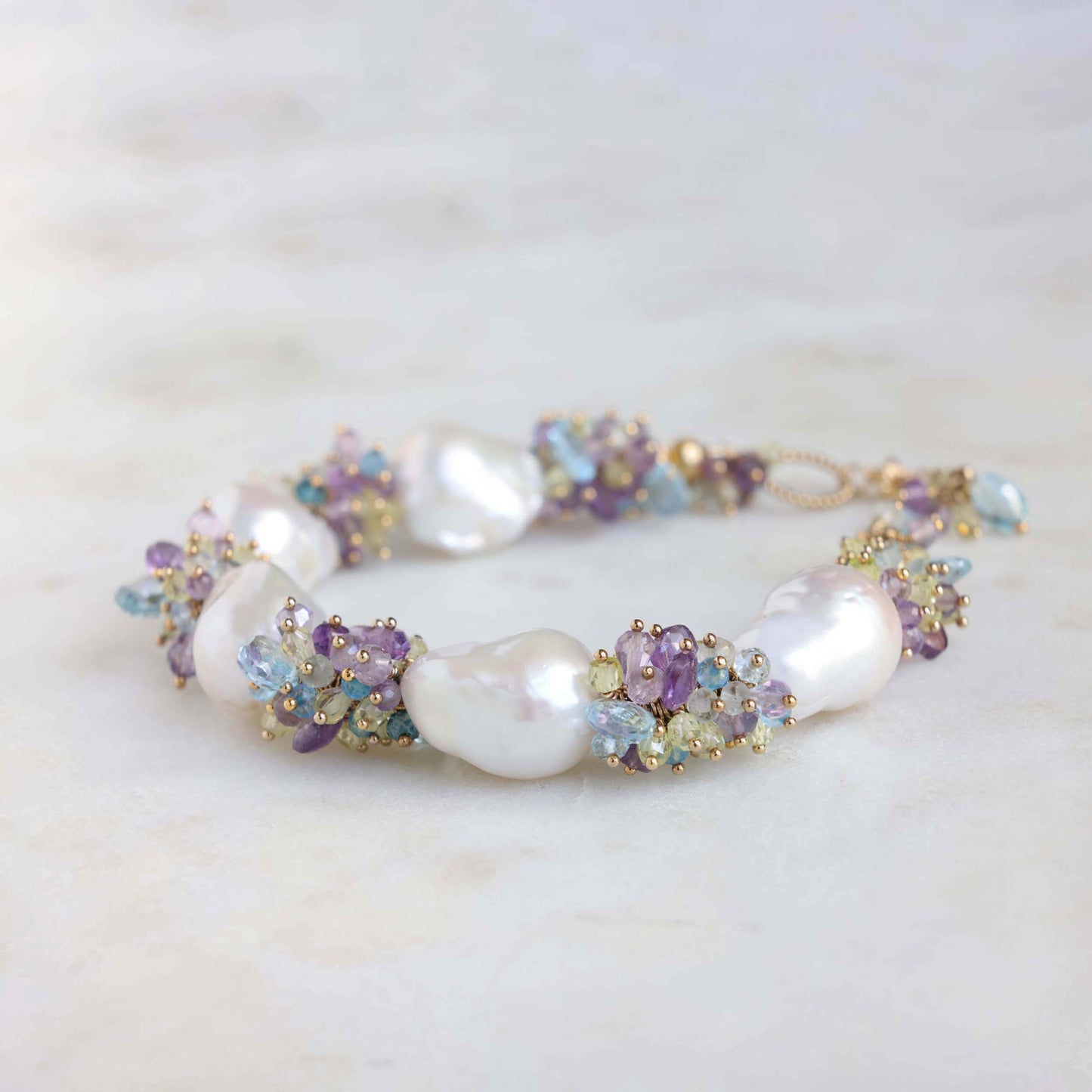 baroque pearl and gemstone bracelet. Gemstones include blue topaz, amethyst, lemon quartz